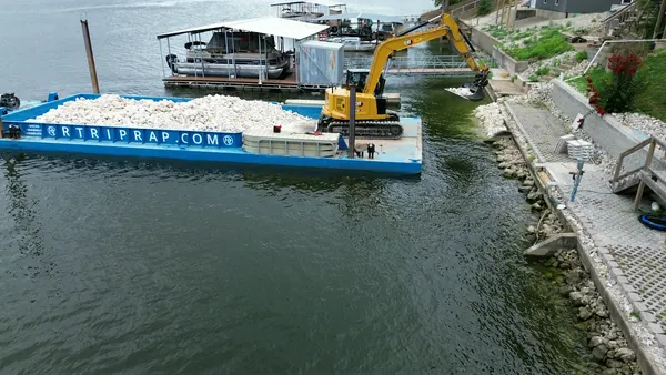 Loaded rock barge working a shoreline